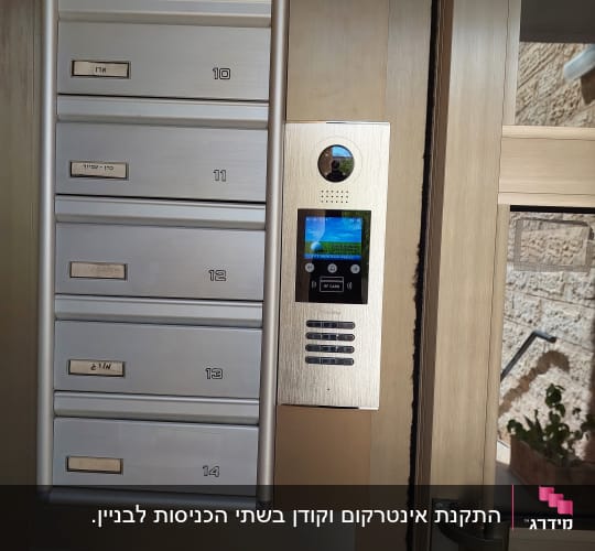 אינטרקום עם מצלמה ומסך ליד תיבות דואר
